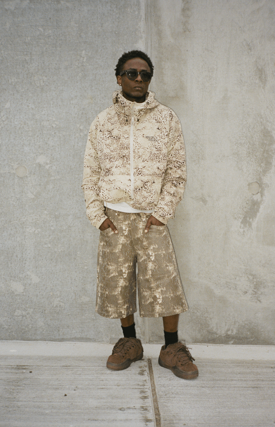 Wide snake-print denim shorts on model, metallic tan and light pattern, mid-thigh length